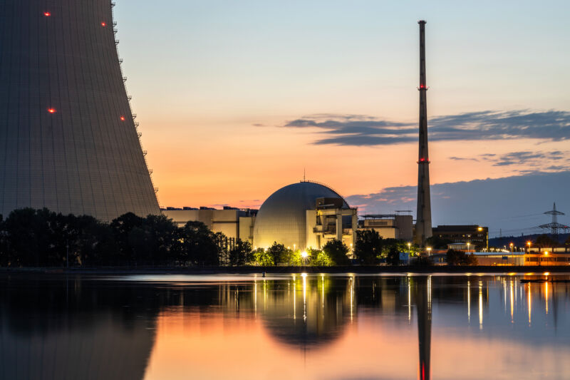 Image of a concrete tower and dome near a river.